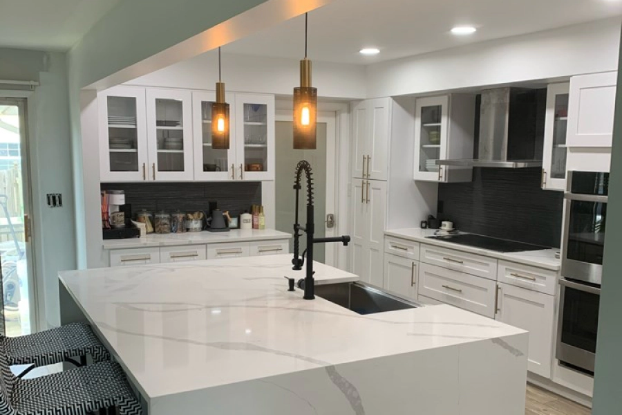 white kitchen with white cabinets and a countertop with a marbled cover